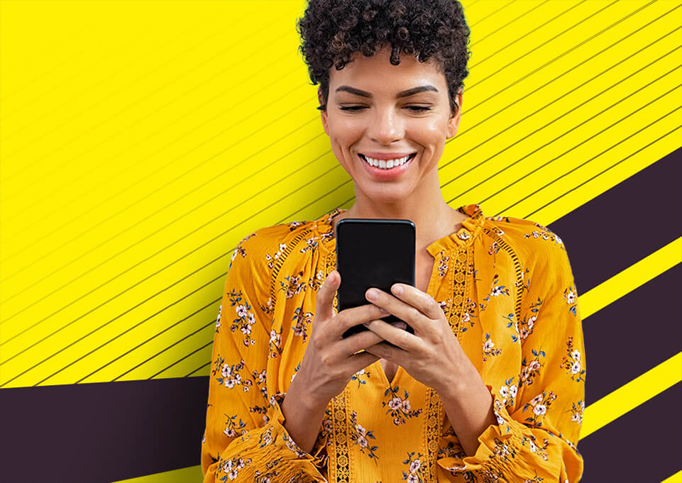 Woman looking at her phone with a yellow background.